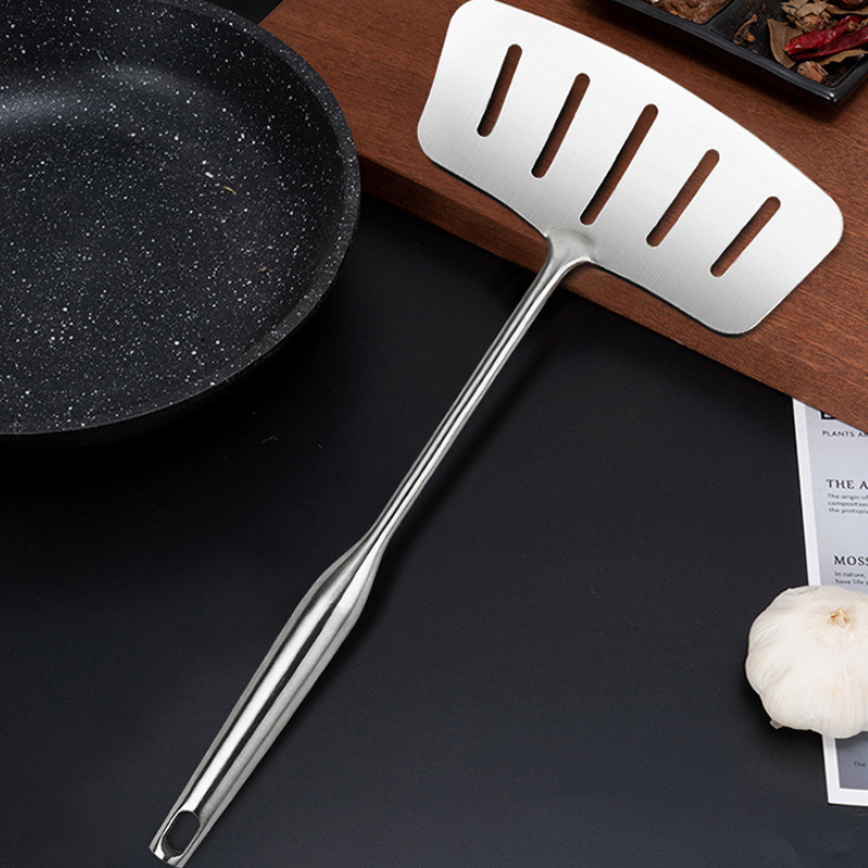 Le Mishio Metal Wok Spatula beim Wenden von Fleisch auf heißem Kochfeld