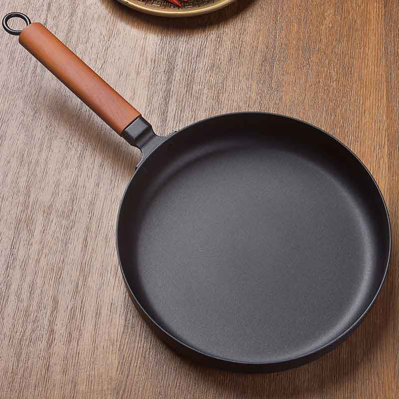 Le Takachiho Karbonstahl-Wok ohne Beschichtung beim Wokken über offener Flamme