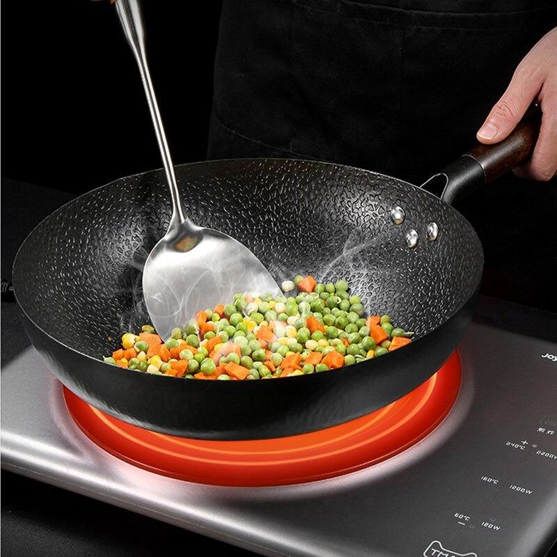 Le Norikura Wok Pfanne 32 cm Carbonstahl in der Hand beim Schwenken gehalten