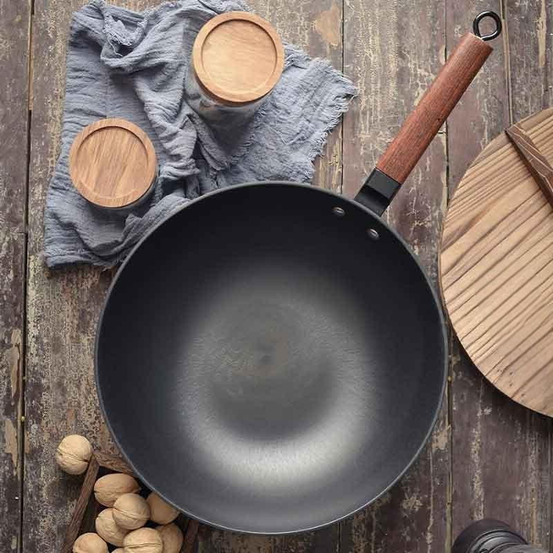 Le Tokaji Karbonstahl-Wok mit Antihaft beim Schwenken von Hand gehalten