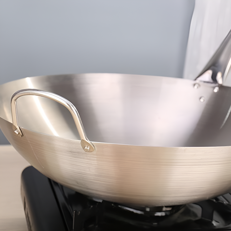 Le Asama Wok Detailaufnahme des Holzgriffs und der Carbonstahl-Oberfläche