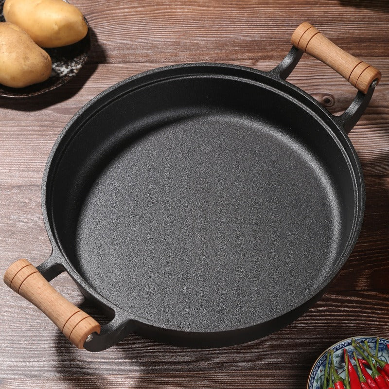 Le Gamaksan massiver Gusseisen-Wok seitlich mit Holzgriff fotografiert